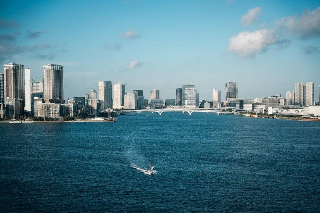 Advanced consumer drone flying against blue sky with city skyline below
